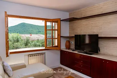 a living room with a couch and a tv and a window at Ca L’Oscana in Bigues i Riells
