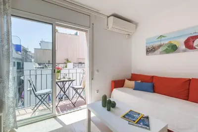 a living room with a couch and a balcony at Nova Apartment by Hello Homes Sitges in Sitges