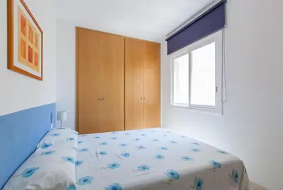 a bedroom with a bed and a wooden cabinet at SOUL by Hello Homes Sitges in Sitges