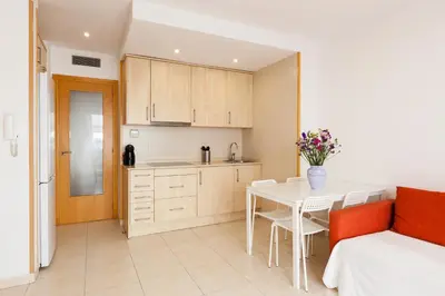 a kitchen and dining room with a table and chairs at SOUL by Hello Homes Sitges in Sitges