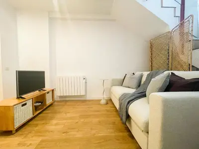 a living room with a couch and a television at Boutique Llobregat in Hospitalet de Llobregat