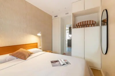 a bedroom with a white bed with a magazine on it at Sagrada Familia Apartment by Olala Homes in Barcelona