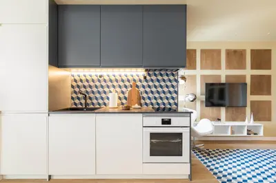 a kitchen with white cabinets and a stove top oven at Sagrada Familia Apartment by Olala Homes in Barcelona