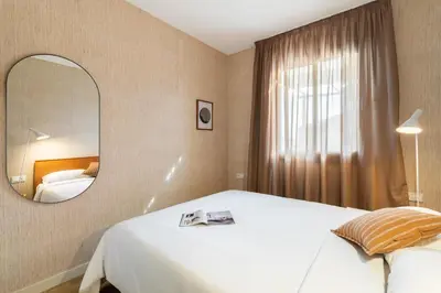 a hotel room with a bed and a mirror at Sagrada Familia Apartment by Olala Homes in Barcelona