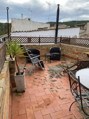 a patio with chairs and tables and a potted plant at Ca la Trini - turisme rural in Torrellas de Foix