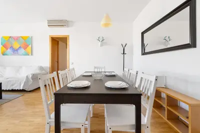 a dining room with a black table and white chairs at Families & Groups 4BR2BA by Sagrada in Barcelona