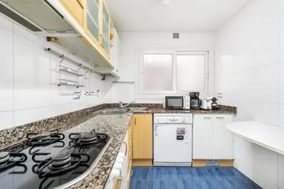 a kitchen with white cabinets and a stove top oven at Families & Groups 4BR2BA by Sagrada in Barcelona