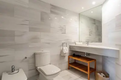 a bathroom with a toilet and a sink and a mirror at Canela Homes BARCELONA DIAGONAL MAR in Barcelona