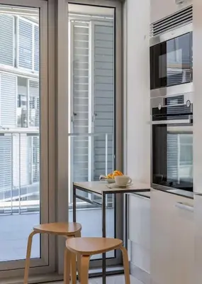 a kitchen with a table and two chairs and a microwave at Canela Homes BARCELONA DIAGONAL MAR in Barcelona