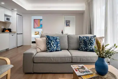 a living room with a gray couch with blue pillows at Habitat Apartments Teatre in Hospitalet de Llobregat