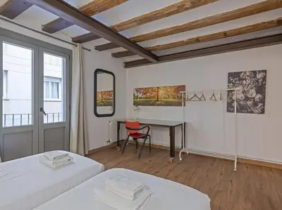 a room with two beds and a desk and a table at Las Ramblas, comfort in BCN for 8 persons in Barcelona