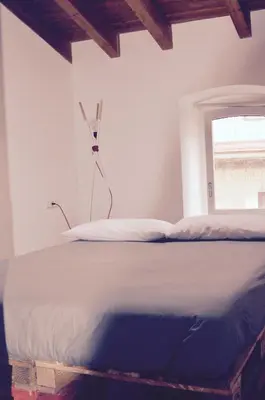 a white bed in a room with a window at CasaOller in Manresa