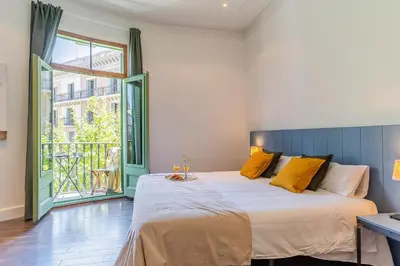 a bedroom with a bed and a large window at Canela Homes BARCELONA FAMILY in Barcelona