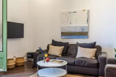 a living room with a brown couch and a glass table at Canela Homes BARCELONA FAMILY in Barcelona