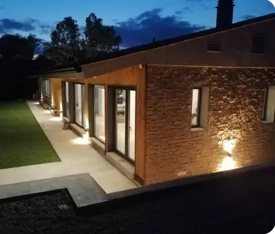 a brick building with lights on the side of it at Casa Natura Montseny in El Brull