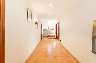 a hallway with white walls and a tile floor at Large 5-Bed Villa, mountain and beach, at 30' from Barcelona & 10' from F1 Circuit in Vallromanas