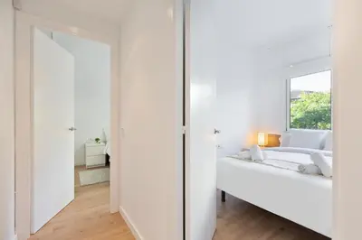 a white bedroom with a bed and a mirror at Suites Barcelona Park Güell in Barcelona