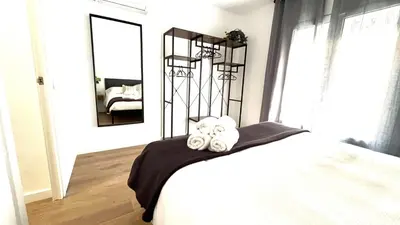 a bedroom with a bed with a black blanket and a mirror at Centro con terraza blco by Prestigi in Terrassa