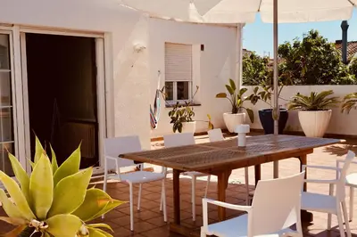 a wooden table and chairs on a patio at Sant Guillem in Vilassar de Mar
