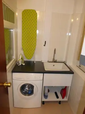 a small kitchen with a sink and a washing machine at Apartment La Rosa (Blaumar) in Sant Andreu de Llavaneres