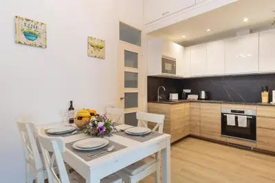 a kitchen and dining room with a white table and chairs at Sagrada Familia Apartment in Barcelona