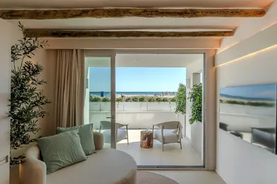 a living room with a couch and a view of the ocean at Apartamentos Azul in Castelldefels