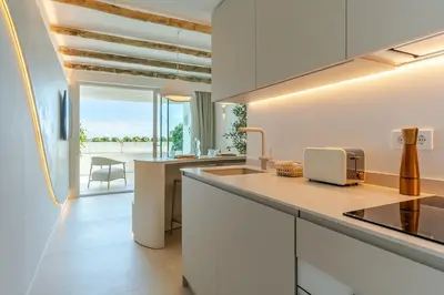 a kitchen with white cabinets and a counter top at Apartamentos Azul in Castelldefels