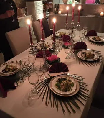 a table with plates of food and candles on it at The Villa Sunlight in Sitges