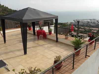 a black umbrella on top of a balcony with plants at The Villa Sunlight in Sitges