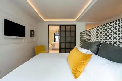 a bedroom with a large bed with a yellow pillow at Serras Barcelona in Barcelona