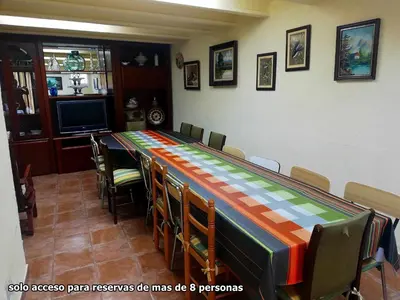 a long table in a room with chairs and a television at Joanet Guarda turismo familiar en plena naturaleza in La Guardiola