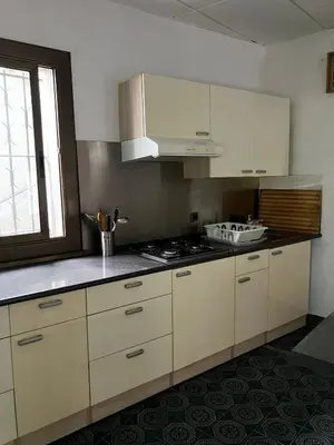 a kitchen with white cabinets and a stove top oven at Loft Rural Barcelona in Barcelona