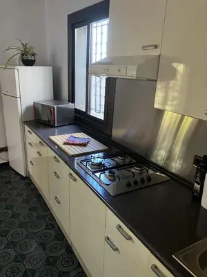 a kitchen with a stove and a white refrigerator at Loft Rural Barcelona in Barcelona