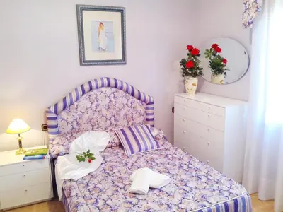 a bedroom with a purple bed and a dresser at Villa Antonia in Mataró