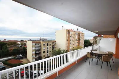 a balcony with a table and a view of a city at Narciso views in Vilassar de Mar