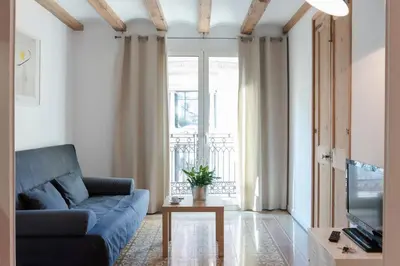 a living room with a blue couch and a tv at Central Verdete in Barcelona