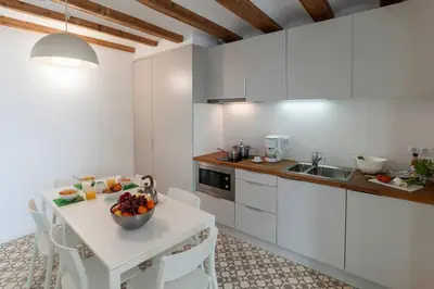 a kitchen with a table with a bowl of fruit on it at Central Verdete in Barcelona