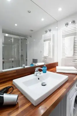 a white bathroom with a sink and a mirror at Central Verdete in Barcelona