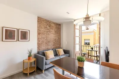 a living room with a couch and a table at Decô Apartments Barcelona-Sants in Barcelona