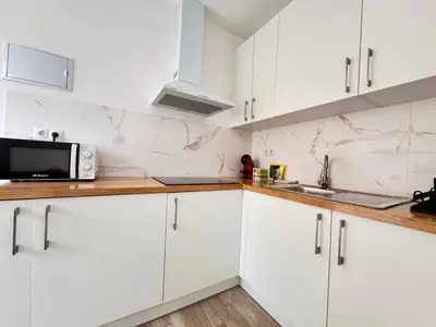 a white kitchen with white cabinets and a microwave at Crysoyle Apartment II Barcelona Next to Camp Nou in Hospitalet de Llobregat