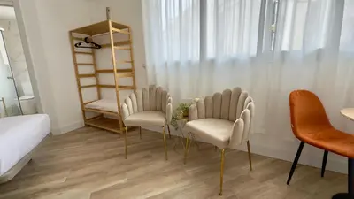 a room with two chairs and a table and a bed at Crysoyle Apartment II Barcelona Next to Camp Nou in Hospitalet de Llobregat