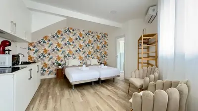 a room with a bed and chairs in a kitchen at Crysoyle Apartment II Barcelona Next to Camp Nou in Hospitalet de Llobregat