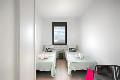 a room with two beds and a window at Seaside Badalona Apartment in Badalona