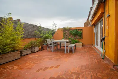 a patio with a table and chairs on a building at BALMES - Atico con terraza en Sant Gervasi in Barcelona