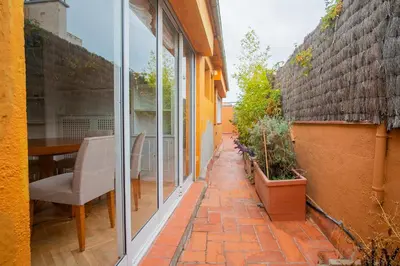 a patio with a table and chairs and a window at BALMES - Atico con terraza en Sant Gervasi in Barcelona