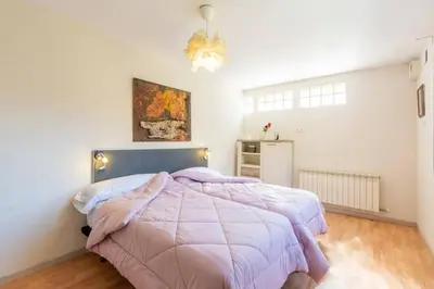 a bedroom with a large bed with a purple comforter at Casa Mar Blava con piscina comunitaria junto Barcelona Centro in Alella