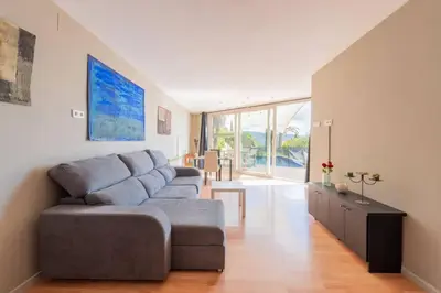 a living room with a couch and a table at Casa Mar Blava con piscina comunitaria junto Barcelona Centro in Alella