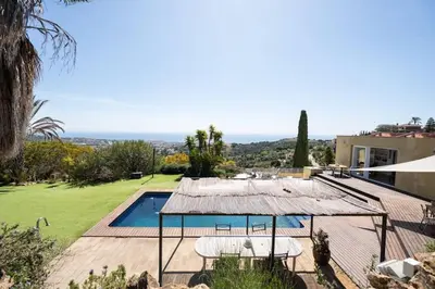 a villa with a swimming pool and a house at Casa Mar Blava con piscina comunitaria junto Barcelona Centro in Alella