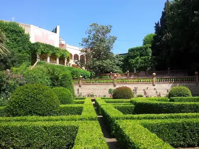 a garden with trimmed hedges and a building at Casa Victor Riu in Piera