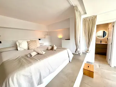 a bedroom with a white bed with two stuffed animals on it at Pandi's Place in Sant Pere de Ribes